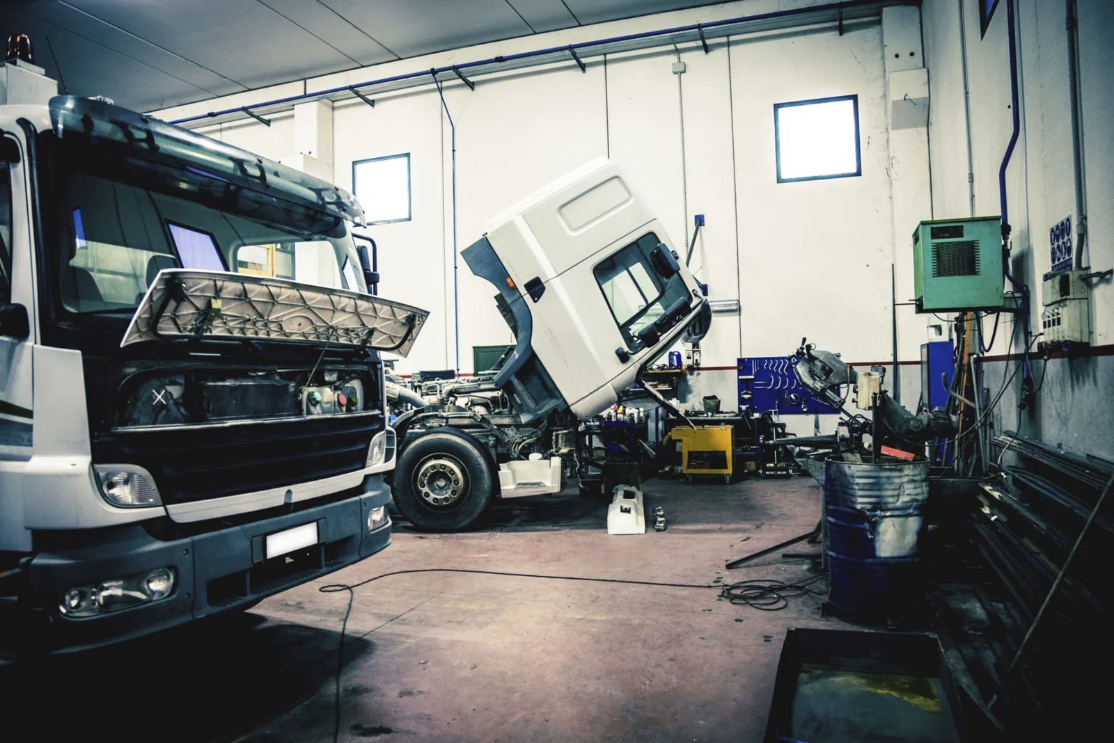 Mechanic servicing a heavy vehicle diesel engine in a clean workshop