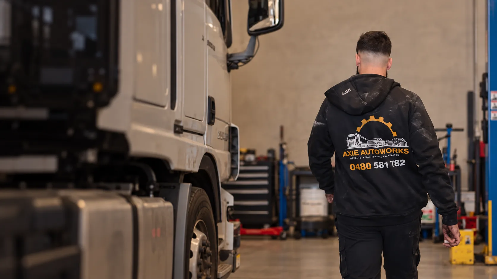 Axie Autoworks mechanic walking through the Yennora workshop beside a truck